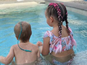 Children with colourful braided hair in pool